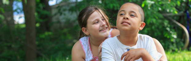 two young kids smiling outdoors